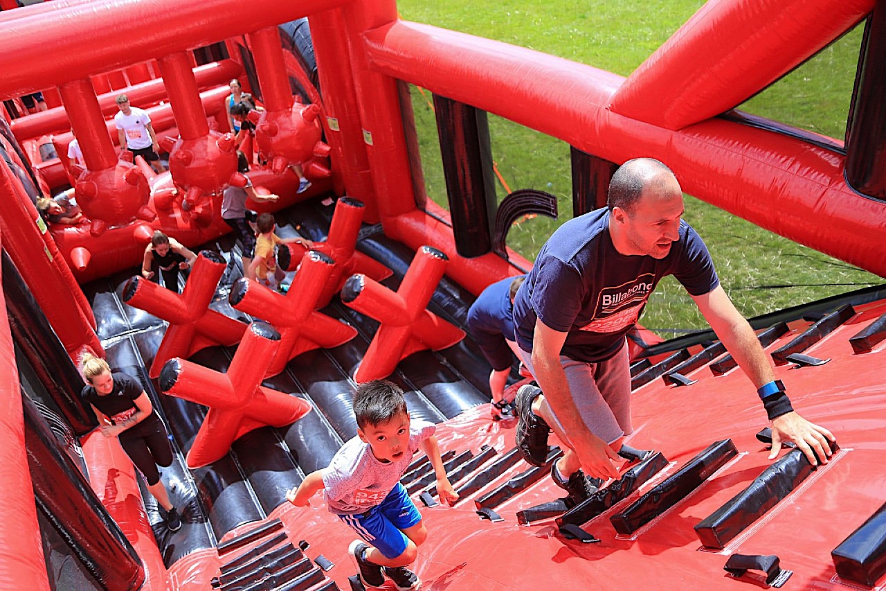 People climbing up the wall of an inflatable obstacle course.