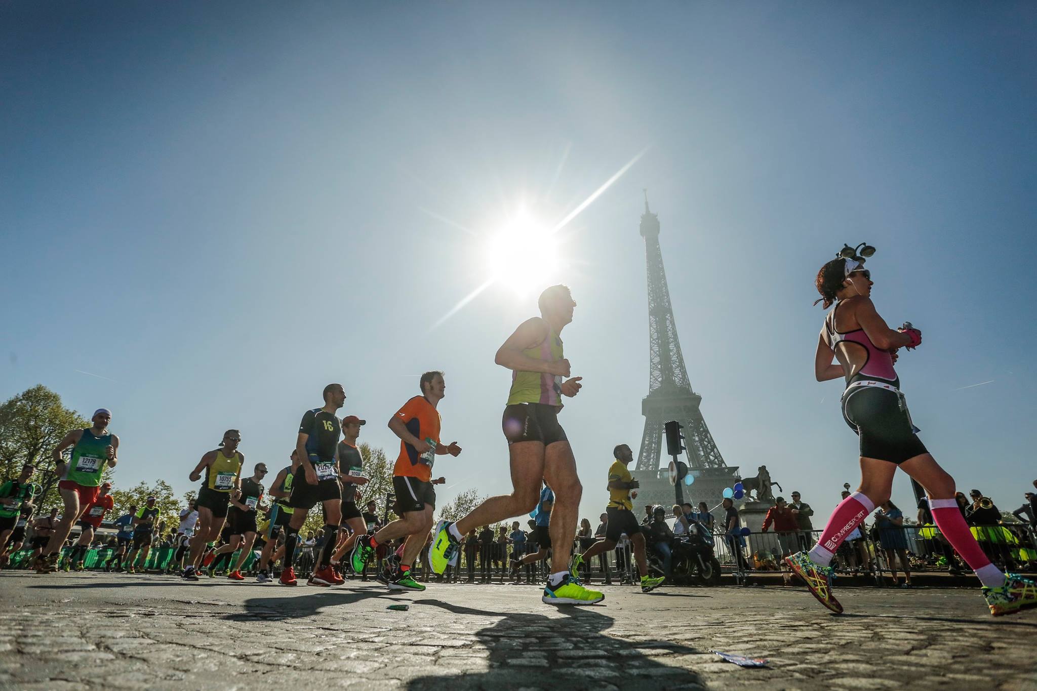 Group of people running near the Eiffel Tower in Paris.