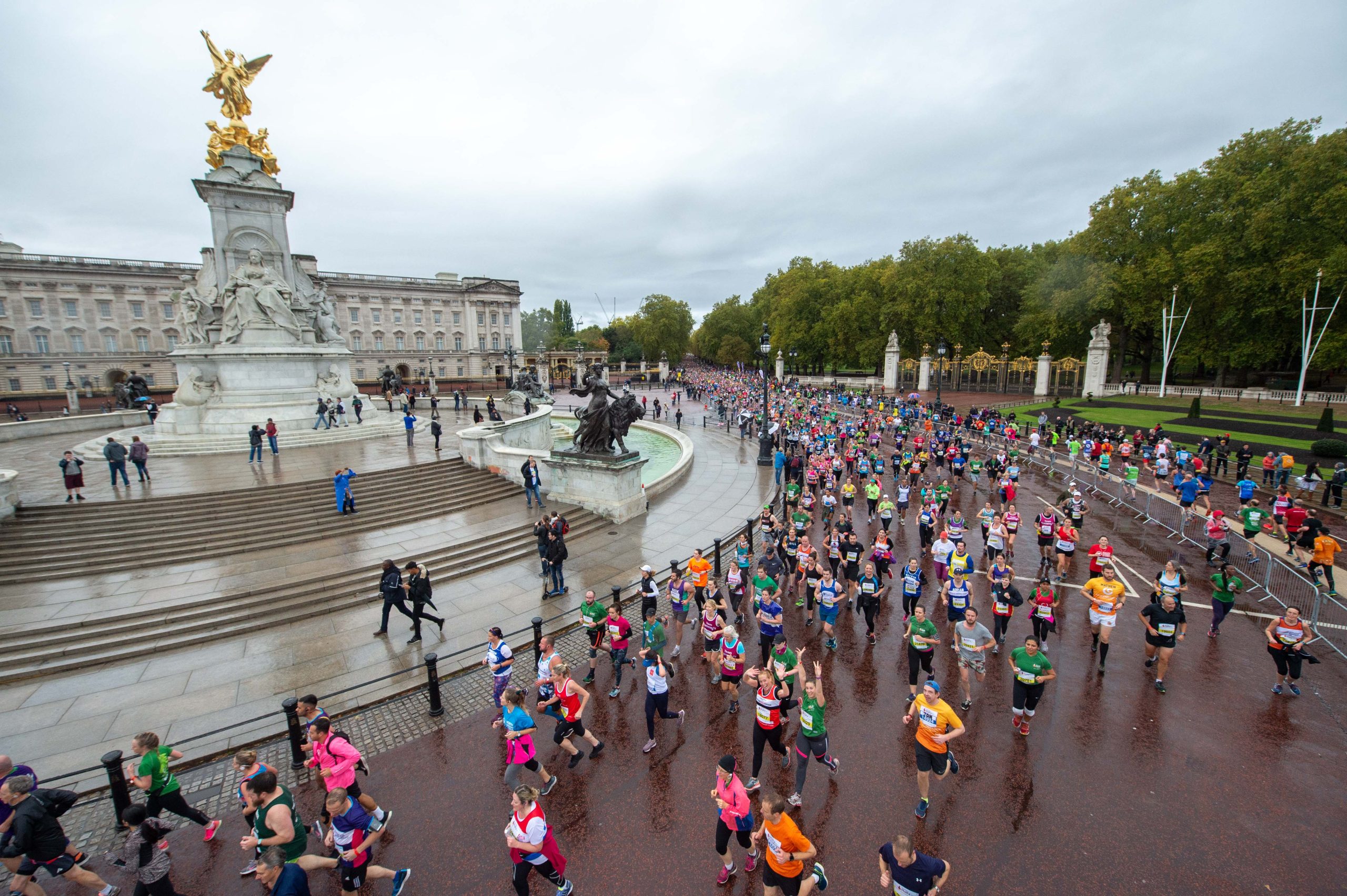 Group of runners running past Buckingham Palace in London.