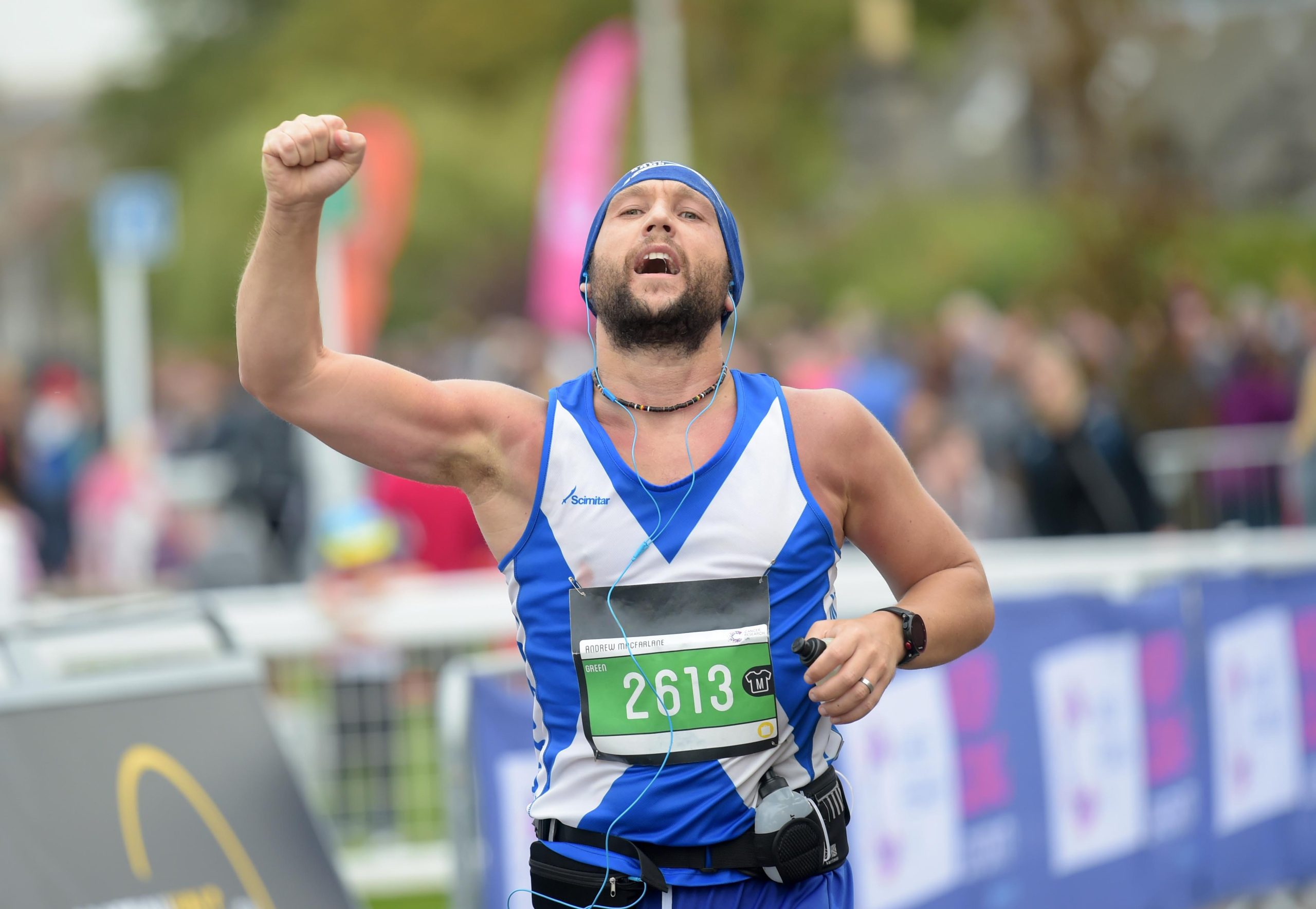 Man raising his fist in celebration during a running event.