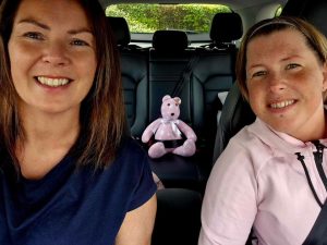 Michelle and Wendy in the car ready to begin their adventure with their teddy bear mascot Mable sitting in the back.