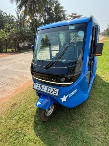 Front view of one of Dogstar's new electric tuk-tuks. The body is blue and the Dogstar logo is printed on the front left hand side below the windscreen.